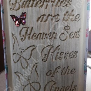 May include: A book art sculpture with the text "Butterflies are the Heaven Sent Kisses of the Angels" and a red butterfly embellishment.