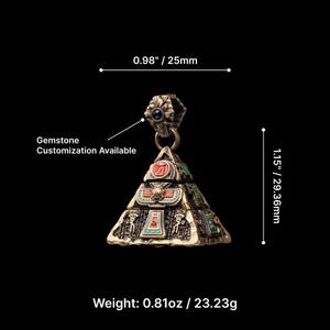 May include: A bronze-colored pyramid pendant with green and red accents, featuring hieroglyphic designs. The pendant is 1.15 inches (29.36mm) tall and 0.98 inches (25mm) wide, with a weight of 0.81oz (23.23g). Text on the image states "Gemstone Customization Available."