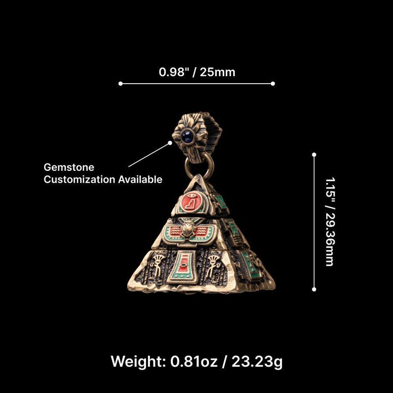 May include: A bronze-colored pyramid pendant with green and red accents, featuring hieroglyphic designs. The pendant is 1.15 inches (29.36mm) tall and 0.98 inches (25mm) wide, with a weight of 0.81oz (23.23g). Text on the image states "Gemstone Customization Available."