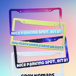 May include: A stack of license plate frames in various colors, including purple, yellow, black, and white. Each frame has a unique message, such as "NICE PARKING SPOT, RITA!" and "GREY NOMADS". The frames are made by MAYRAYSHANDMADE.