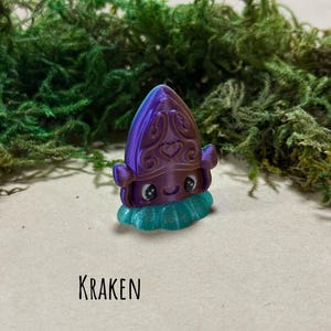 May include: A 3D-printed Kraken figurine in purple and teal, with a decorative design on its head and a frilly base. The word "KRAKEN" is printed below the figurine. The HayHaysHandmade logo is at the bottom.