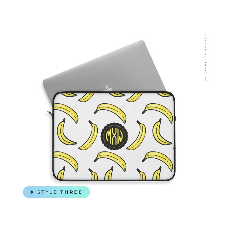 May include: A white laptop sleeve with a black border and a pattern of yellow bananas. The sleeve has a black circle with the letters "MXW" in yellow.