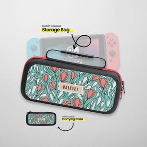 Könnte beinhalten: Eine schwarze Switch-Konsolen-Aufbewahrungstasche mit rotem Reißverschluss und Griff. Die Tasche hat ein türkisfarbenes Blumenmuster mit rosa Blüten und weißen Blättern. Der Name "BRITNEY" ist auf einem beigen Etikett aufgedruckt.