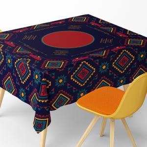May include: A navy blue tablecloth with a geometric pattern in red, teal, yellow, and orange. The design includes diamond shapes, triangles, and rectangular patterns. A red circle is in the center. A yellow chair with an orange seat is in the foreground.