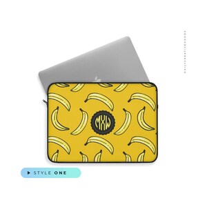 May include: A yellow laptop sleeve with a black outline and a repeating pattern of yellow bananas. The sleeve has a black circle with the initials "MXW" in white.