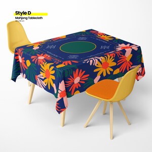 May include: A navy blue Mahjong tablecloth, 140 x 140 cm, with a floral pattern in orange, yellow, and pink. The tablecloth has a green oval in the center and is set on a table with yellow chairs.