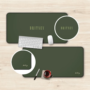 May include: Two green desk mats with the name "BRITNEY" printed on them in a light green color. The top mat has a circle with the name "BRITNEY" printed inside. The bottom mat has a white pen, a cup of coffee, and the name "brittney" written in cursive.