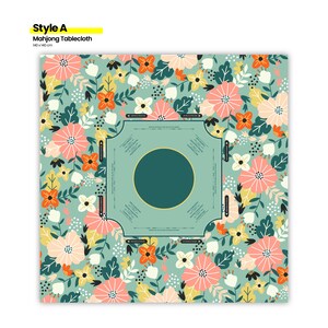 May include: A square Mahjong tablecloth with a floral pattern. The design features a light teal background with scattered flowers in shades of pink, orange, yellow, and white. The center has a teal circle and a square border with text. The tablecloth is 140 x 140 cm.