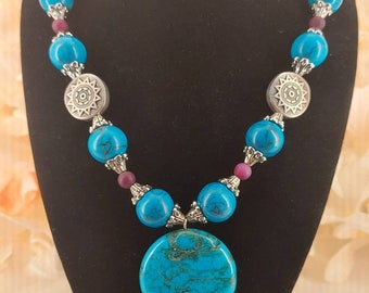 Turquoise pendant necklace w/acrylic turquoise and purple agate beads. Silver bead caps, silver medallions, cable chain and toggle clasp.