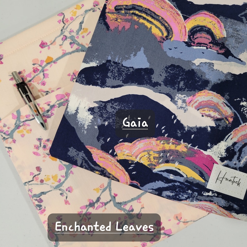 Op de afbeelding: Een roze en blauwe stof met een kleurrijk abstract ontwerp. De stof heeft de woorden "Gaia" en "Huntek" erop gedrukt. De stof is gelabeld met "Enchanted Leaves".