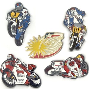 Puede incluir: Cinco pines de metal coloridos que representan a corredores de motocicletas en varias poses. Los pines están detallados con números, logotipos y patrocinadores como Marlboro, Castrol y Michelin.