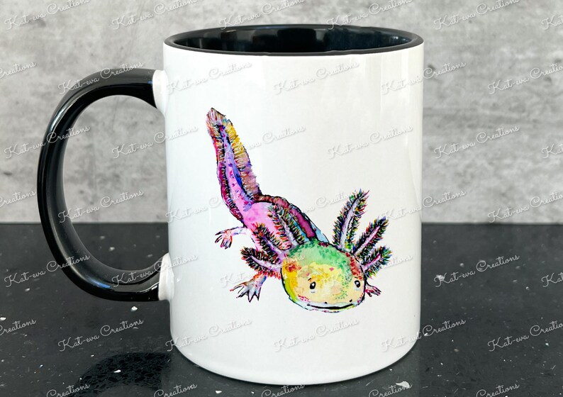 Pu&ograve; includere: Una tazza in ceramica bianca con un manico nero e un bordo nero. La tazza presenta un'illustrazione colorata di un axolotl, un tipo di salamandra, con colori rosa, verde e giallo.
