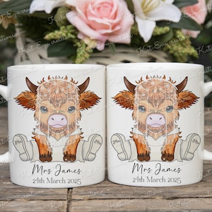 May include: Two white ceramic mugs with a cartoon Highland cow wearing a veil and holding a bouquet of flowers. The mugs have the text "Mrs James" and "24th March 2025" printed on them.