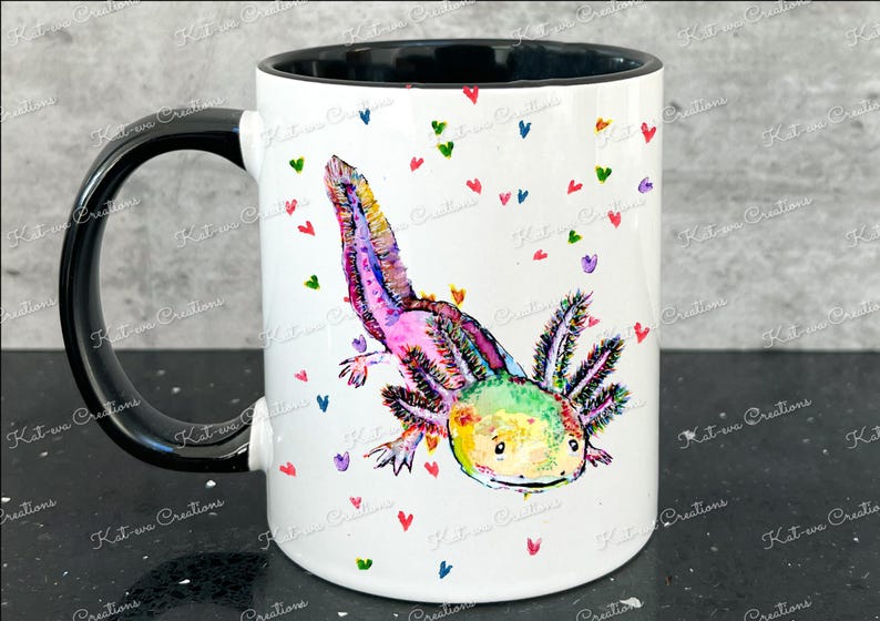 Pu&ograve; includere: Una tazza in ceramica bianca con manico nero presenta un'illustrazione colorata di un axolotl con tonalit&agrave; rosa, verdi e gialle. L'axolotl &egrave; circondato da piccoli cuori colorati.