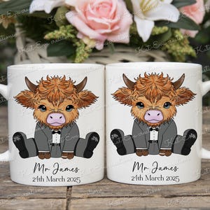 May include: Two white ceramic mugs with a cartoon illustration of a Highland cow wearing a tuxedo. The mugs have the text "Mr. James" and "24th March 2025" printed on them.