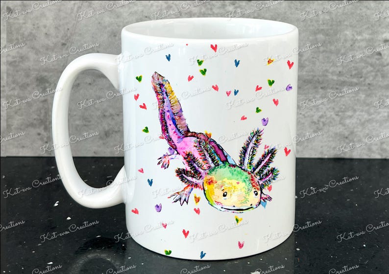 Pu&ograve; includere: Tazza in ceramica bianca con un'illustrazione colorata di un axolotl con colori arcobaleno e accenti rosa. L'axolotl &egrave; circondato da piccoli cuori di vari colori.