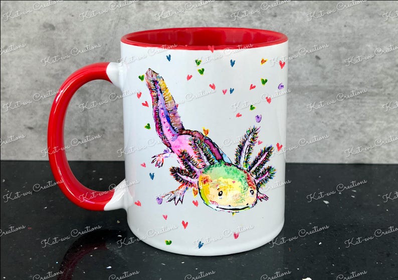 Pu&ograve; includere: Una tazza in ceramica bianca con bordo e manico rossi. La tazza presenta un'illustrazione colorata di un axolotl con colori rosa, verde e giallo. Lo sfondo &egrave; bianco con cuori rosa, verdi e blu sparsi.