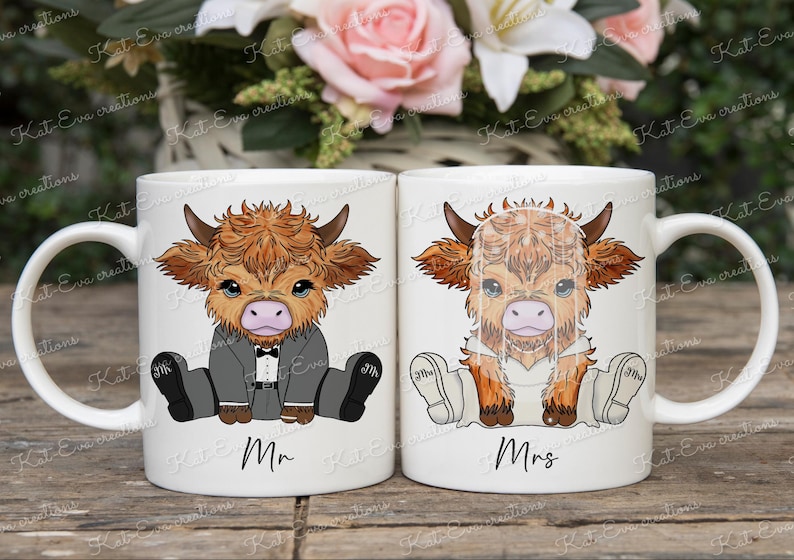 May include: Two white ceramic mugs with handles. The mugs feature illustrations of cartoon Highland cows wearing wedding attire. One mug says "Mr." and the other says "Mrs."