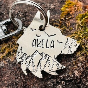wolf dog tag in nickel silver engraved with mountain, tree and bird design