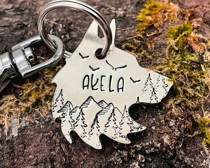 wolf dog tag in nickel silver engraved with mountain, tree and bird design
