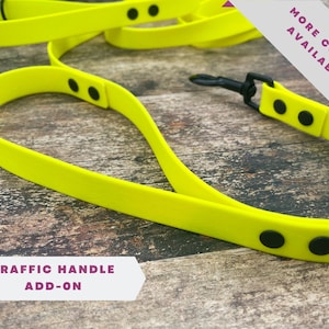 Puede incluir: Una correa para perro de color amarillo brillante con herrajes negros y un asa de tráfico adicional. La correa está hecha de un material duradero, similar al caucho. Hay más colores disponibles.