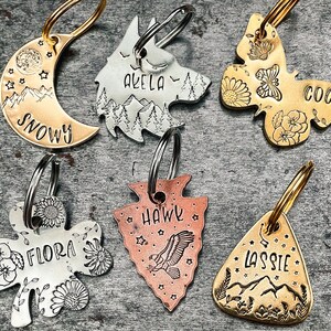 cute pet id tags in various shapes: moon, wolf head, butterfly, shamrock, arrowhead, guitar pick