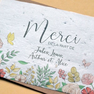 May include: A white card with a floral border and the text 'Merci de la part de Jules, Louis, Arthur et Alice'.