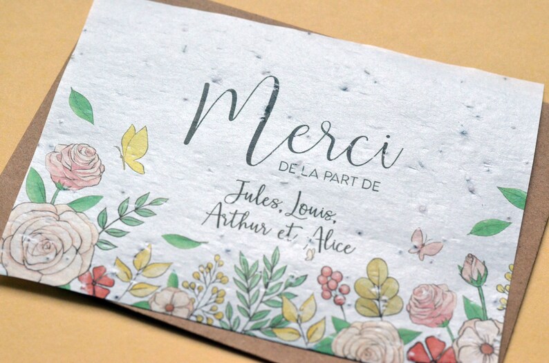 May include: A white card with a floral border and the text 'Merci de la part de Jules, Louis, Arthur et Alice'.