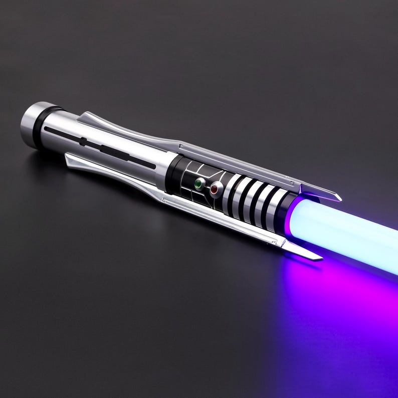 May include: A silver lightsaber with a black and silver handle and a purple blade. The lightsaber is turned on and the blade is glowing.