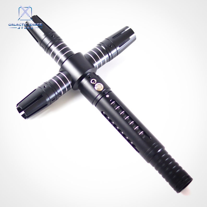 Puede incluir: Sable de luz negro con guarda transversal y detalles plateados. El mango tiene ranuras verticales y un bot&oacute;n. El sable de luz tiene cuatro hojas, cada una con una punta distinta. Logotipo de Galactic Saber Store en la esquina superior izquierda.