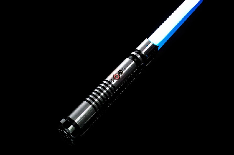 K&ouml;nnte beinhalten: Ein silbernes Lichtschwert mit einer blauen Klinge. Das Lichtschwert hat einen schwarzen Griff mit einem strukturierten Griff und einen roten Knopf.