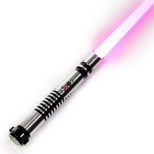 K&ouml;nnte beinhalten: Ein silbernes Lichtschwert mit einem schwarzen Griff und einer pinkfarbenen Klinge. Das Lichtschwert hat einen roten Knopf am Griff.