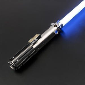 May include: A silver lightsaber with a black handle and a blue blade. The lightsaber is lit and the blade is glowing.