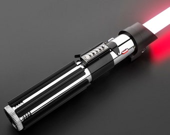 May include: A black and silver lightsaber toy with a red light blade. The lightsaber has a black handle with silver accents and a red button on the side.