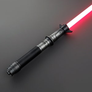 May include: A black lightsaber with a red blade. The lightsaber has a textured grip and a black hilt with a silver accent.