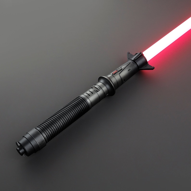 May include: A black lightsaber with a red blade. The lightsaber has a textured grip and a black hilt with a red button.