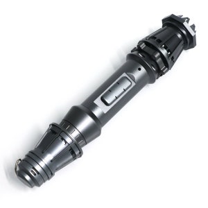 May include: A dark gray metal lightsaber with a textured surface and a black button. The lightsaber has a pointed tip and a rounded handle.