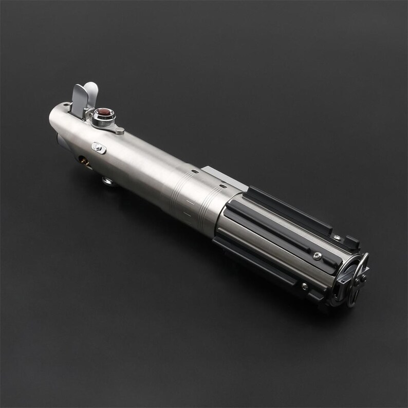 May include: A silver lightsaber with a black handle and a red button. The lightsaber is a popular toy and collectible for fans of Star Wars.