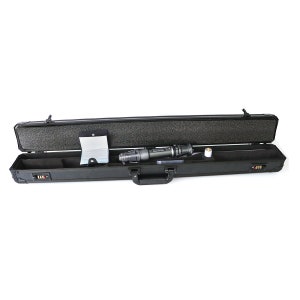 May include: A black hard-shell case with a black handle is open, revealing a black and silver device and a white booklet. The case has a foam interior and multiple latches.