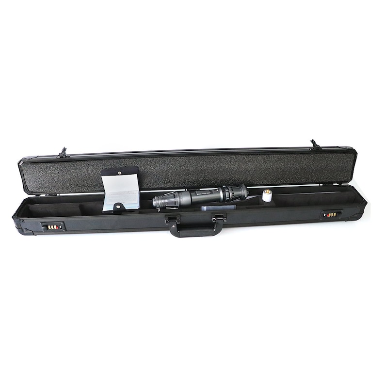 May include: A black hard-shell case with a black handle is open, revealing a black and silver device and a white booklet. The case has a foam interior and multiple latches.