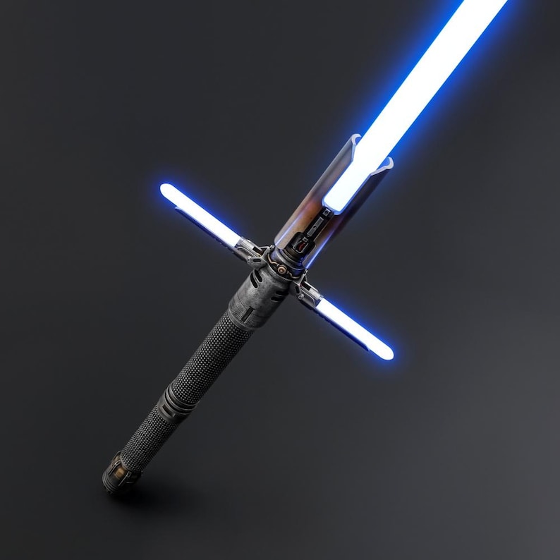 Puede incluir: Imagen detallada de un sable de luz azul con dise&ntilde;o de guarda cruzada. El mango tiene un agarre texturizado gris oscuro y un emisor marr&oacute;n y plateado. La hoja principal y las hojas de la guarda emiten un brillo azul brillante sobre un fondo oscuro.