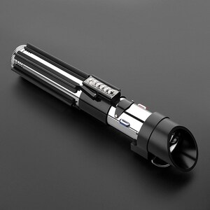 Op de afbeelding: Een zwart en zilveren lightsaber-speelgoed met een zwarte handgreep en een zilveren blad. De lightsaber heeft een knop op de handgreep en een rood licht aan het einde van het blad.