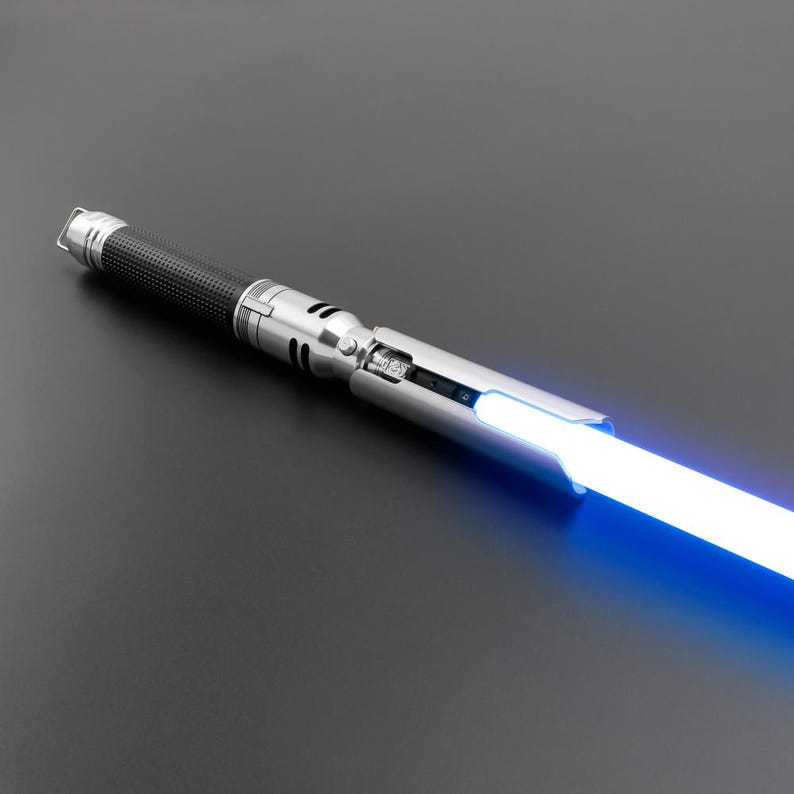 May include: A silver lightsaber with a black handle and a blue blade. The lightsaber is switched on and the blade is glowing.