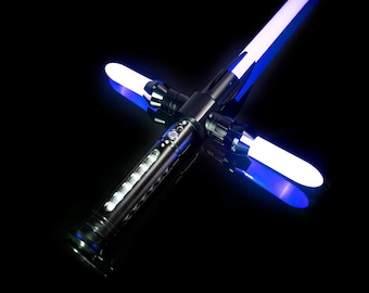 May include: A black lightsaber with a blue blade, the blade is lit and the lightsaber is laying on a black surface.