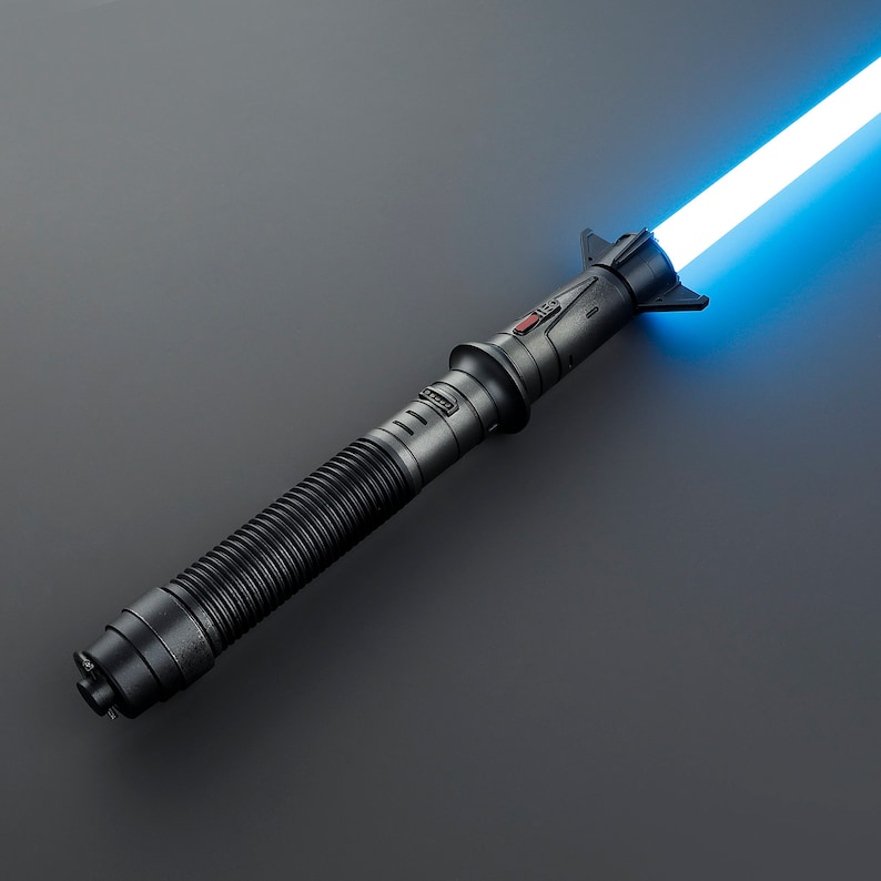 May include: A black lightsaber with a blue blade. The lightsaber has a textured grip and a black handle with a red button.