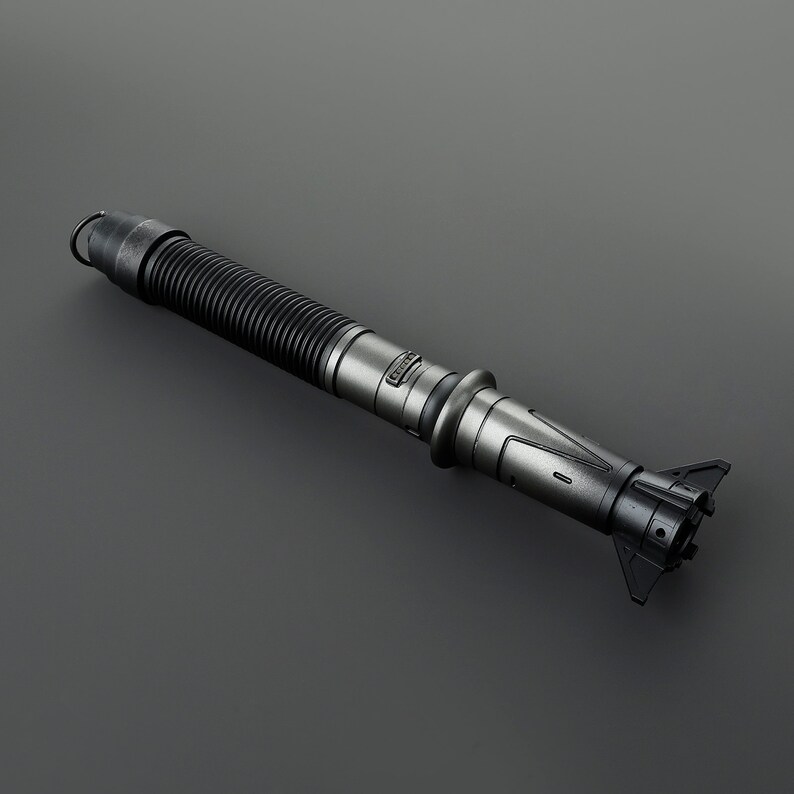 May include: A black and silver lightsaber with a textured grip and a detailed hilt. The lightsaber has a black, ribbed, telescoping section.