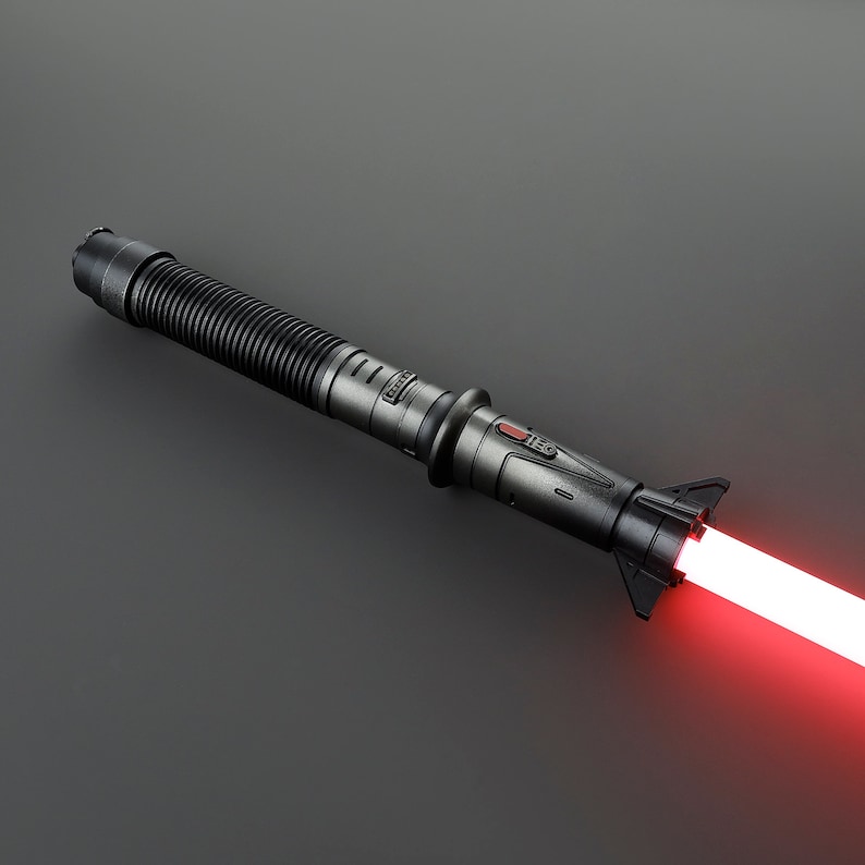 May include: A black lightsaber with a red blade. The lightsaber has a textured handle and a red button.