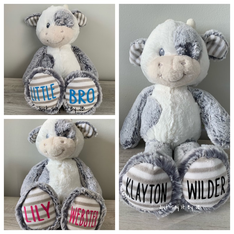 May include: Three plush cow toys with personalized names on the bottom of their feet. The first cow has the names "Little Bro" on its feet. The second cow has the names "Klayton Wilder" on its feet. The third cow has the names "Lily Webster" on its feet. All three cows have gray and white fur.