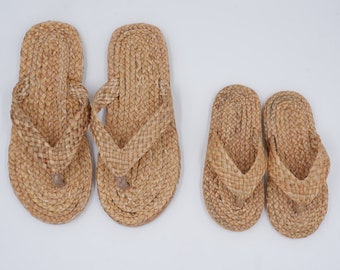 May include: Three pairs of woven straw sandals, two larger pairs and one smaller pair. The sandals are all tan in color and have a simple design.