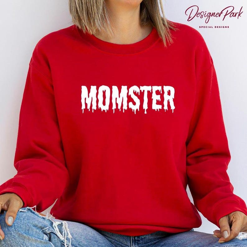 A person wearing a red sweatshirt with the word "MOMSTER" printed on it.